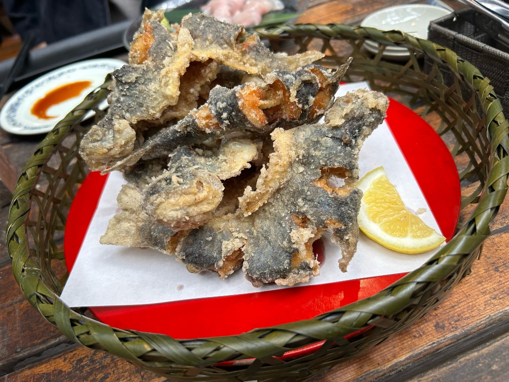 ざるの上に小魚の唐揚げがこんもりと盛られ、レモンが添えられている（藍鱗の食堂）